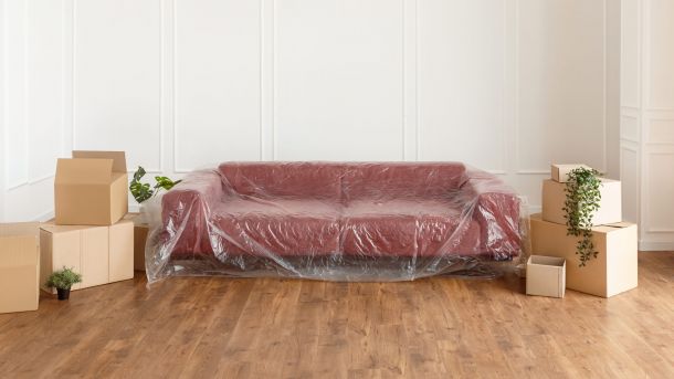 Red couch in plastic wrap